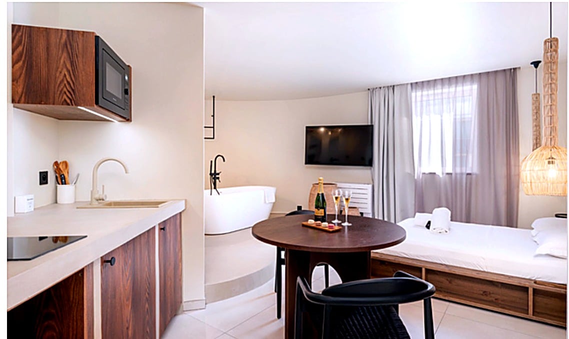 Love room sur mesure amenagee par Codesign Concept dans un hotel a Lyon, avec cuisine, salle de bain ouverte et coin repas integres