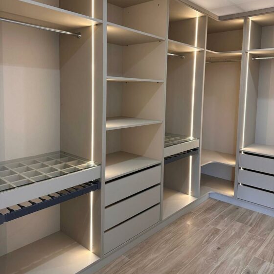 Dressing d'angle sur mesure en mélaminé avec éclairage LED intégré, penderies, tiroirs et vitrine à bijoux, réalisé par Codesign Concept pour un cabinet d'architecte à Lyon